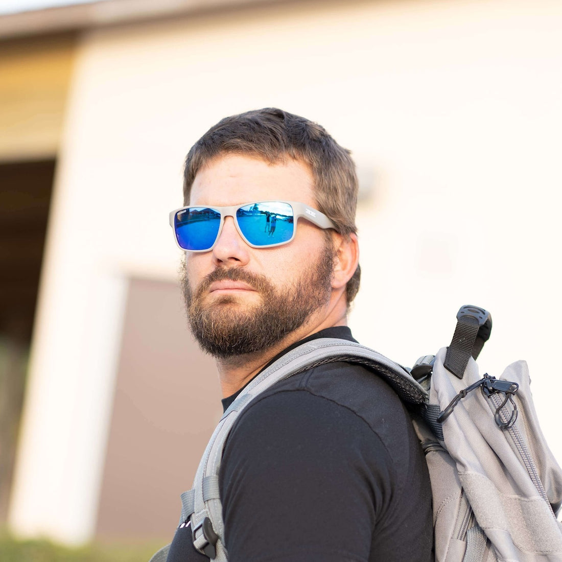 man with backpack wearing epoch Polarized sunglasses