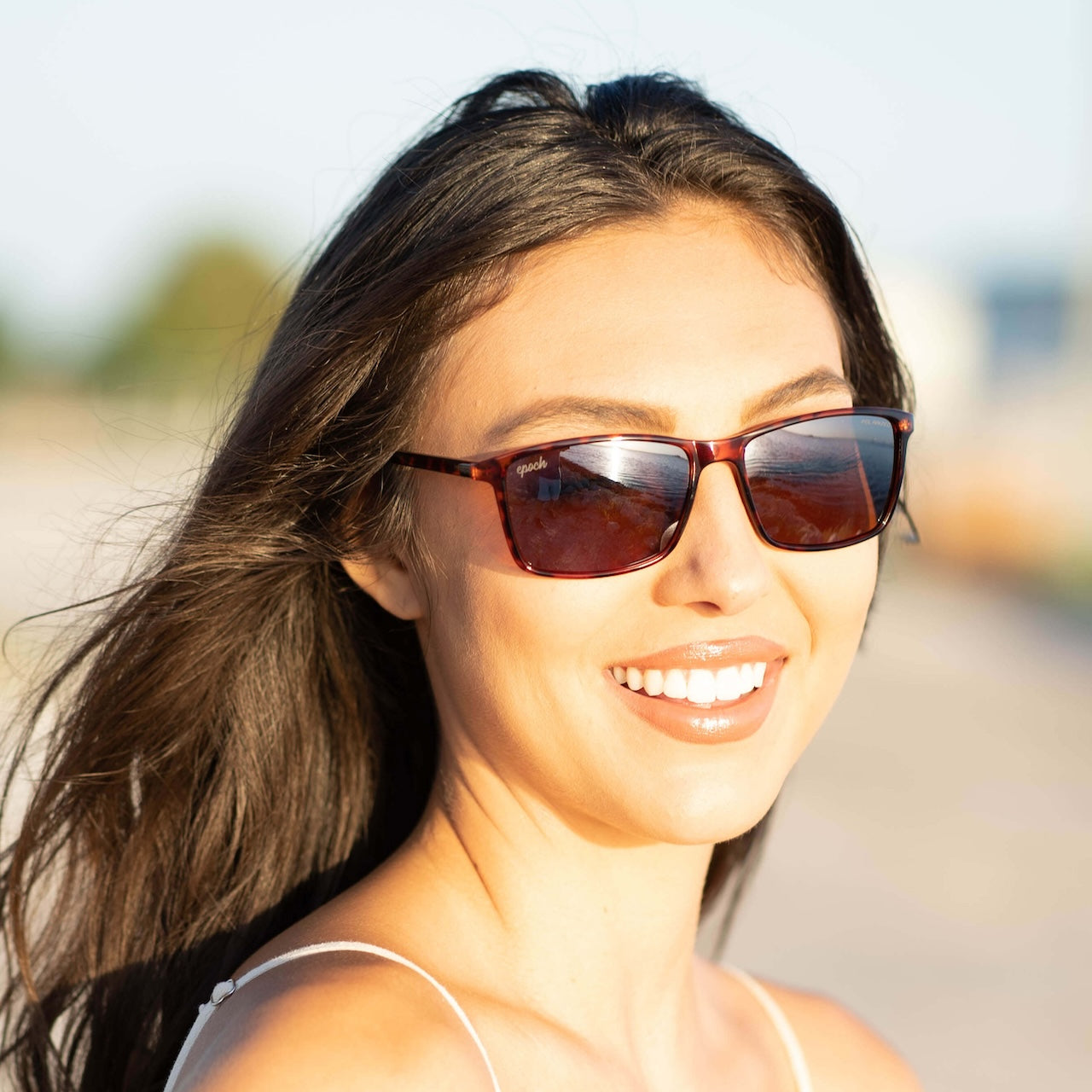 A woman wearing Murphy shades and smiling outdoors.