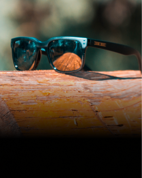 black smoke romeo sunglasses laying on wood block